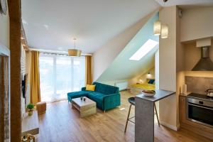 - un salon avec un canapé bleu et un lit dans l'établissement Apartament Ceglany - centrum, prywatne miejsce parkingowe, klimatyzacja, à Kielce