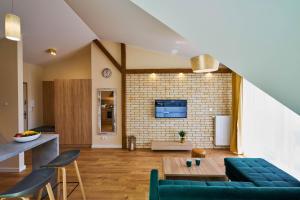 ein Wohnzimmer mit einem blauen Sofa und einer Ziegelwand in der Unterkunft Apartament Ceglany - centrum, prywatne miejsce parkingowe, klimatyzacja in Kielce