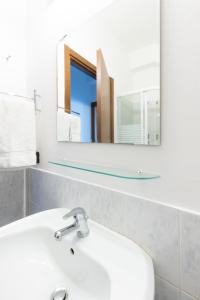 ein Badezimmer mit einem weißen Waschbecken und einem Spiegel in der Unterkunft Marialuisa's Home - Le Rive Del Lago in Desenzano del Garda
