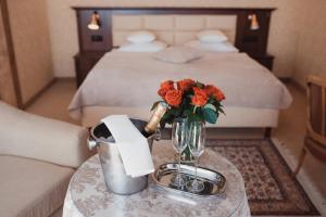 a table with a vase of flowers on a bed at Żabi Dwór - HOTEL - RESTAURACJA - SPA in Zielona Góra