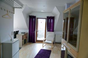 a living room with purple curtains and a chair at Ferienwohnung Am Klosterberg 6 in Bad Brückenau