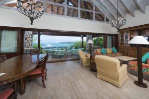a living room with a table and chairs and a dining room at Canouan Estate Resort & Villas in Canouan