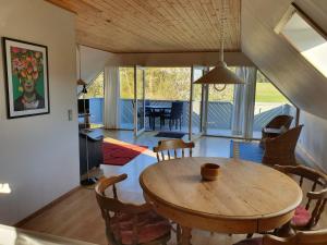 a dining room with a wooden table and chairs at Feriestedet Skovly in Klemensker