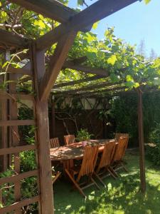 a wooden table and chairs under a pergola at Le Loft in Aulnay-sous-Bois