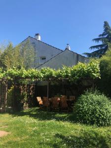 a garden with a table and chairs under a pergola at Le Loft in Aulnay-sous-Bois