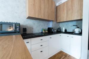 a kitchen with white cabinets and a microwave at Apartament Solna - jedyny taki #Lublin in Lublin