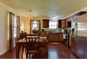 a kitchen with a wooden table and a refrigerator at Austin Escape in Cedar Creek