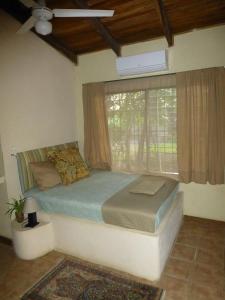 a bedroom with a bed and a large window at Villa Silvestre in Coco