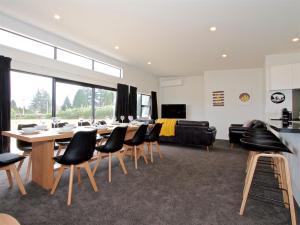 a dining room with a long table and chairs at Mountain Adventure Spa Escape - Ohakune Home in Ohakune