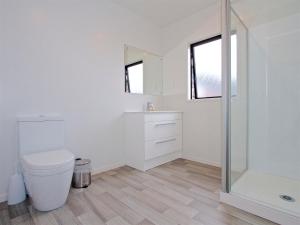 a bathroom with a toilet and a glass shower at Mountain Adventure Spa Escape - Ohakune Home in Ohakune +22 photos