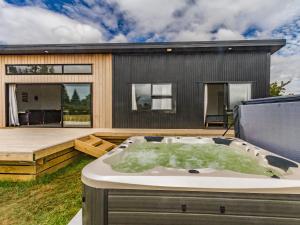 a hot tub on the deck of a house at Mountain Adventure Spa Escape - Ohakune Home in Ohakune