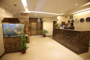 a lobby with an aquarium and a man at a counter at Hotel City Premier in Gurgaon