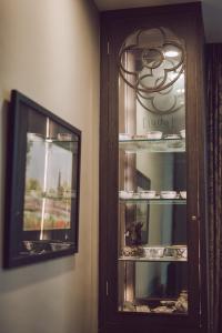 a glass cabinet with dishes in it next to a mirror at iuDia Hotel in Phra Nakhon Si Ayutthaya