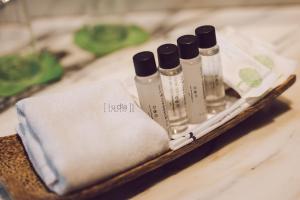 a group of four bottles of liquids sitting on a table at iuDia Hotel in Phra Nakhon Si Ayutthaya