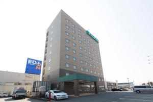um edifício de hotel com carros estacionados num parque de estacionamento em Hotel Econo Kameyama em Kameyama