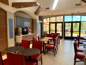 a restaurant with tables and chairs and windows at Holiday Inn Express Hotel & Suites El Dorado Hills by IHG in El Dorado Hills
