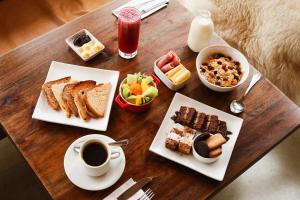 una mesa con dos platos de desayuno y una taza de café en Hostal Boutique Factoria Patagonia en Puerto Natales