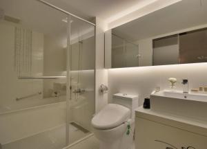 a bathroom with a toilet and a shower and a sink at Forward Hotel Taipei Nangang in Taipei