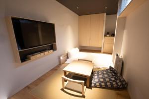 a small living room with a table and a television at GEN HOTEL KAMAKURA in Kamakura