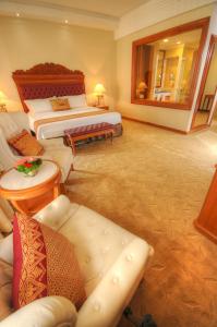 a hotel room with two beds and a couch at Royale Chulan Kuala Lumpur in Kuala Lumpur