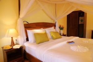 
a bed with a white comforter and pillows at Thanh Kieu Beach Resort in Phú Quốc
