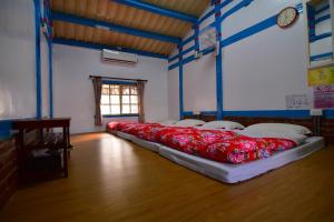una camera con due letti con cuscini rossi sul pavimento di 嘉義泊岸居民宿 a Lucao