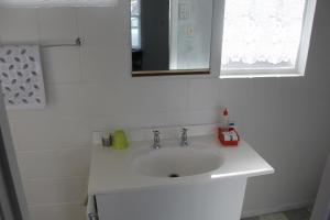 a white bathroom with a sink and a mirror at Taihape Motels in Taihape