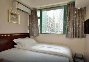 a bedroom with two beds and a window at 名都旅馆 in Hong Kong
