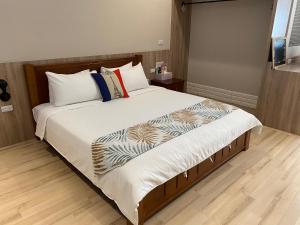 a bedroom with a large bed with white sheets and pillows at Enjoy Homestay in Tainan