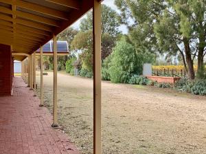 una fila di pali in un parco con una panchina di Coonawarra Units a Coonawarra