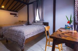 婆羅浮屠的住宿－The Omah Borobudur，一间卧室配有两张床、一张桌子和一张书桌