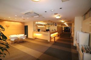 a room with a kitchen with a counter and chairs at Hotel Green Arbor in Sendai