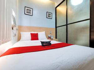 a bedroom with a large white bed with red pillows at RedDoorz near Trade School Gensan in General Santos