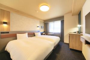 a hotel room with two beds and two lamps at Richmond Hotel Yamagata Ekimae in Yamagata