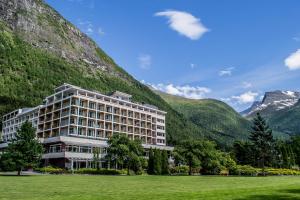 a large building with mountains in the background at Hotel Alexandra Loen in Loen