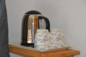 a coffee pot and two mugs on a shelf at Haus Trausner in Hallstatt