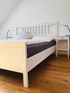 a bedroom with a white bed with a desk at Ferienhaus am Tor zur Wachau in Eggendorf