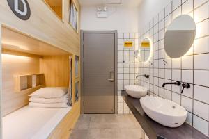 a bathroom with two sinks and a bed at Kunlun Youth Boutique Hostel in Jilian