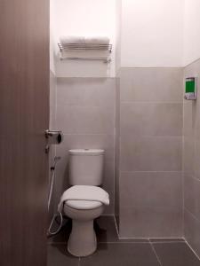 a bathroom with a white toilet in a stall at Front One Residence Syariah Mampang in Jakarta