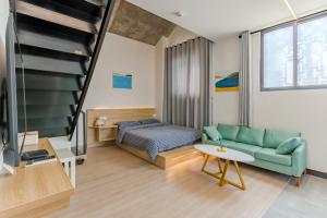 a living room with a couch and a bed and a tv at Kunlun Youth Boutique Hostel in Jilian