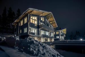una casa grande en la nieve por la noche en Ski-Inn PyhäLinna, en Pyhätunturi