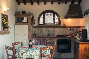 een keuken met een tafel met wijnglazen erop bij CASE&COLLINE Villetta Anita in Montescudaio
