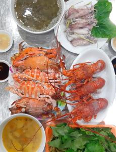 un plato de langostas y otros alimentos en una mesa en Thanh Tu Hotel, en Cửa Lô