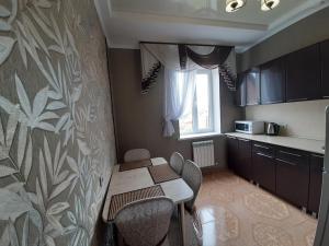 a kitchen with a table and chairs and a window at Семейные Апартаменты in Pyatigorsk