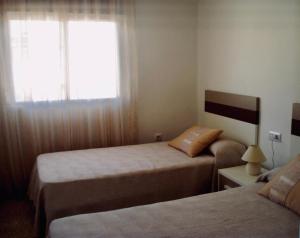 a bedroom with two beds and a window at Apartament La Calita in Peniscola