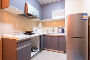 a kitchen with a stainless steel refrigerator and cabinets at Wuhan Wuchang District·Jiyu Bridge in Han-yang-hsien