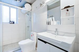 a white bathroom with a sink and a toilet at Wuhan City Wuchang District shahu park in Pingdingshan