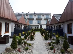 a courtyard of a building with trees and plants at Flaming - domki letniskowe in Rowy