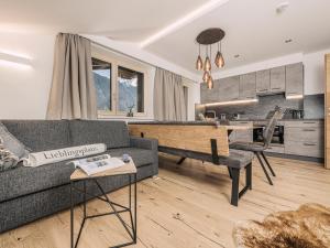 Leuhaus في مايرهوفن: غرفة معيشة مع أريكة وطاولة ومطبخ