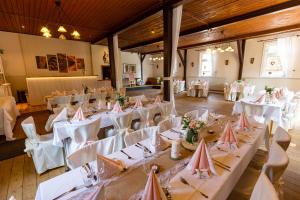 Wegeners Landhaus UG في أويلتسن: غرفة مليئة بالطاولات والكراسي مع مفارش المائدة البيضاء